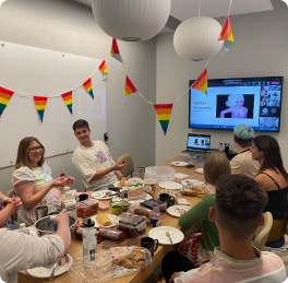 Our colleagues celebrating pride in an office with rainbow bunting and cakes, on a virtual Teams call
