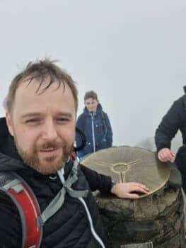One of our colleagues in the rain at the top of Snowdon in Wales
