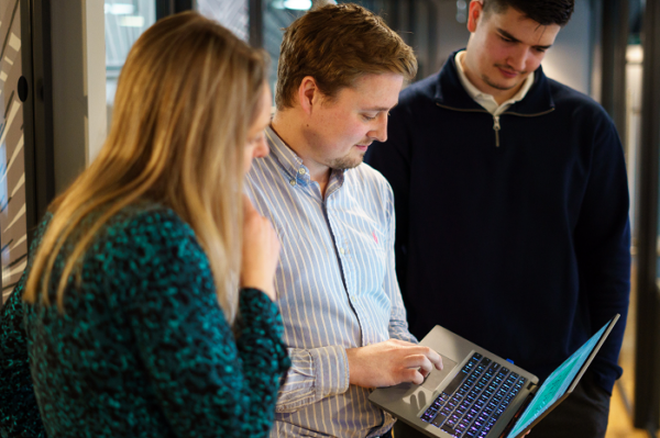 3 people looking at a laptop